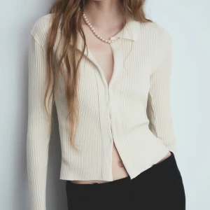 Ribbad cardigan med hyskor - Helt oanvänd. Mjuk och skön tröja med krage och hyskor fram. Ordinarie pris 379kr. Storlek L men passar lika bra M. 