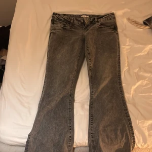 Grå bootcut jeans från Gina Tricot M - Snygga grå jeans från Gina Tricot i bootcut-modell. Jeansen har klassisk femficksdesign, normalhög midja och är tillverkade i ett mjukt denimtyg. Perfekta för dig som gillar en avslappnad men trendig look.