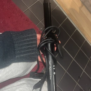 Fasett Professional Series Locktång - Fasett Professional Series locktång med digitala temperaturinställningar och strömbrytare. Svart design, sladd i gott skick. Mindre yttre slitage syns, men fungerar utmärkt för styling av hår. Perfekt för både vardag och fest.