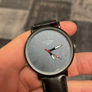 Longines svart klocka med blå urtavla - Klocka från longines med svart läderband och en blå urtavla. Urtavlan är unik med den kristalliska bakgrunden som glänser som diamanter i ljuset. Klockan är en ”dresswatch” och drivs på batteri som byttes i oktober 2025✅Kvitto på allt fås med vid köp!✅priset lågt då klockan är gammal och det finns en pytteliten flisa av safir glaset som gått av på den högra sidan. Man ser den minimala skadan i första bilden om man kollar noga. Pris är diskuterbart!