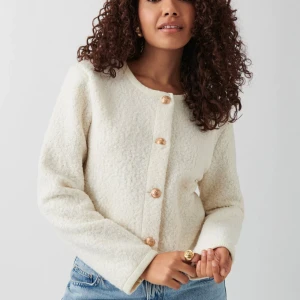 jacka/tjockare kofta från Gina Tricot - Jacka/tjockare kofta från Gina Tricot i storlek S. Den har rund hals, guldiga dekorativa knappar och är kort i modellen. Materialet är fluffigt och mjukt med en teddystruktur.  Erbjuder bundel rabatt vid köp av flera varor 🌸