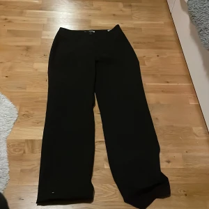 Svarta kostymbyxor från ONLY, strl 36 - Snygga svarta kostymbyxor från ONLY i storlek 36. Byxorna har en klassisk rak och wide passform med midwaist. Materialet är mjukt och följsamt, något längre ben