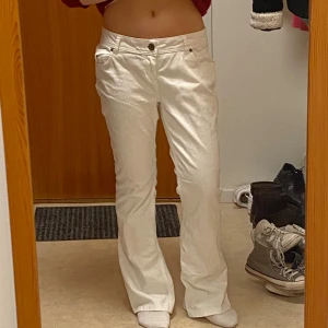 Vita bootcut jeans från Fishbone - Snygga vita jeans från Fishbone med bootcut passform och låg midja. Klassisk femficksdesign framtill och bakfickor med lock och knapp. De är uppsydda! Storlek M