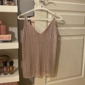 Glittrig topp - Säljer en glittrig, ljusrosa festtopp med smala axelband och v-ringning. Storlek S💋🪩