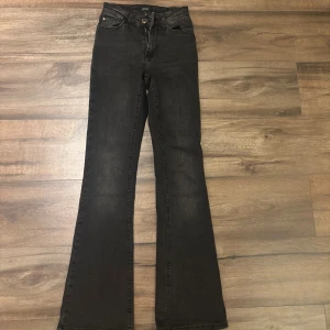 Svarta bootcut jeans från ONLY XS - Snygga svartgråa jeans från ONLY i bootcut-modell med medel hög midja. Jeansen har klassisk femficksdesign, dragkedja och knapp framtill. Materialet är stretchigt denim som sitter skönt. Hör av dig vid frågor❣️❣️