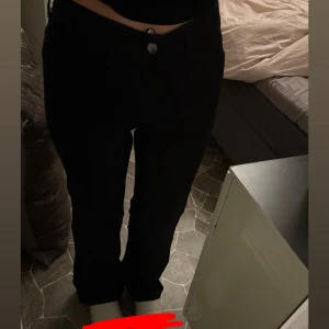 Jeans - Snygga svarta byxor med raka ben och normal midja. Klassisk femficksmodell med knapp och dragkedja framtill. Passar perfekt till en stilren look och är lätta att matcha med olika outfits.