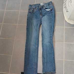 Blå jeans från 157, rak modell - Klassiska blå jeans från 157 med raka ben och normal passform. Jeansen har fem fickor, orangea sömmar och en snygg tvättad look. Tillverkade i slitstarkt denimtyg av bomull. Perfekta för dig som gillar en enkel och tidlös stil.