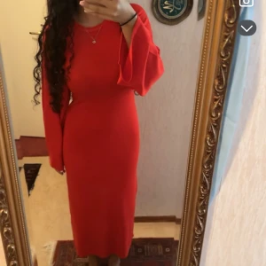 Röd långklänning med vida ärmar - Säljer en snygg röd långklänning med rund hals och vida, långa ärmar. Klänningen har en figurnära passform och är helt enfärgad utan mönster. Perfekt för dig som vill sticka ut med en enkel men elegant look.