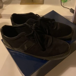 Svarta sneakers från Polo - Säljer ett par snygga svarta sneakers från Polo i storlek 44. De är i bra skick. Ovandelen är gjord av textil och syntet, medan sulan är av gummi. Boxen tillkommer i köpet👍