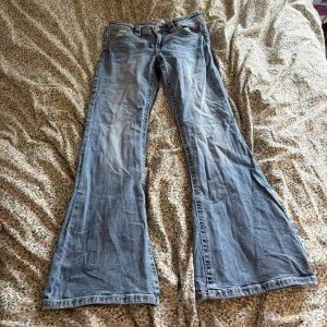 Blå low waist bootcut jeans från Gina Tricot - Snygga ljusblå jeans från Gina Tricot i bootcut-modell. Jeansen har klassisk femficksdesign, normalhög midja och är tillverkade i mjukt bomullsjeansmaterial. Perfekta för dig som gillar en retroinspirerad look med utsvängda ben.