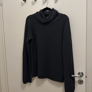 Mörkgrå polotröja från Make Way - Säljer en mörkgrå polotröja från Make Way i storlek S. Tröjan är stickad med grov struktur och har en bred, mysig polokrage. Långärmad och perfekt för kyliga dagar. Enkel och stilren design som funkar till många olika looks.