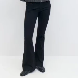 Svarta bootcut byxor med utsvängda ben - Snygga svarta byxor med bootcut och utsvängda ben. Byxorna har klassisk femficksdesign och sitter tajt upptill med en snygg passform. Perfekta för dig som gillar en stilren look med lite edge.