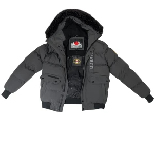 Mörkgrå pufferjacka från Zavetti Canada - Snygg mörkgrå pufferjacka från Zavetti Canada med svart fuskpäls på huvan, broderad logga på ärmen och stora fickor framtill. Jackan har dragkedja, knappar och ribbade muddar. Perfekt för kalla dagar med sin tjocka vaddering och coola look.