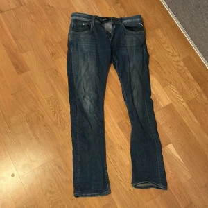 Blå Replay Dave jeans comfort fit 31/32  - Säljer ett par blå Replay Dave jeans i comfort fit med klassisk femficksdesign. Jeansen har raka ben och snygga slitningar framtill för en avslappnad look. Tillverkade i jeansmaterial och passar dig som gillar en normal passform. Nypris 1400