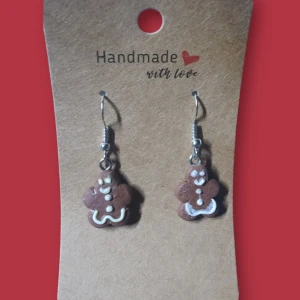 Handgjorda pepparkaksgubbe örhängen - Supersöta handgjorda örhängen med små pepparkaksgubbar i brunt och vitt. Perfekta för dig som vill ha något unikt och lekfullt till vintern eller julen. Hängande modell med silvriga krokar och detaljerad dekor i vitt.