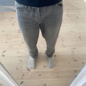 Grå jeans i relaxed fit, storlek 33/34 - Säljer ett par grå jeans med klassisk femficksdesign och rak passform. Jeansen har en snygg tvättad look och är tillverkade i jeansmaterial. Perfekt för dig som gillar en enkel och stilren vibe. Passar dig som vill ha lite loose fit utan att det blir för baggy.                            (Jack & Jones chris)