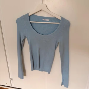 Ljusblå ribbad tröja från Reserved - Supersnygg ljusblå ribbad tröja från Reserved med rund halsringning och lång ärm. Tröjan är figurnära och har en mjuk, stretchig känsla som sitter perfekt. Perfekt att styla med jeans eller kjol för en fräsch look.