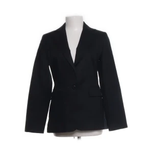 svart kavaj / références / 38 - En svart, klassisk kavaj med två knappar framtill och fickor med lock. Kavajen har en skräddad passform och är perfekt för en stilren look. Långa ärmar och enkel design gör den lätt att matcha med olika outfits. Ärmlängd 60cm, axelbredd 40cm