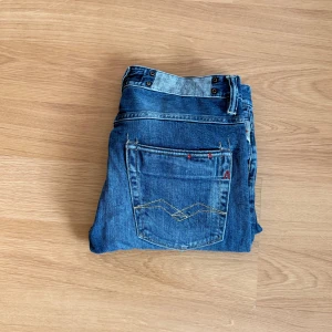 Replay Vadan - Tvär feta replay vadan jeans i blå wash, storlek 28-32. Konstgjorda slitningar som för perfekt look. Slim fit.
