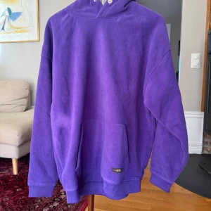 Lila fleece hoodie med huva Redefined Rebel - Säljer en lila hoodie i mjuk fleece från HH. Tröjan har huva, magficka och ribbade muddar vid ärmslut och nederkant. Perfekt för kyliga dagar när du vill vara både bekväm och snygg.