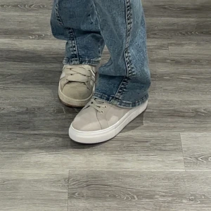 Ljusgråa k.cobler skor - Snygga gråa sneakers från k.cobler med silverfärgade öljetter och klassisk snörning. Skorna har en platt sula och är tillverkade i syntetmaterial med en stilren och minimalistisk design. Perfekta för dig som gillar en clean och fräsch look. De är knappt använda och säljs inte längre, därav priset. De är köpta för 1300.💞