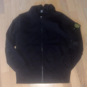 Snygg Stone island zip hoodie beställd från Stone island och är äkta - Svart stone island zip hoodie storlek SMALL och är äkta och knappt använd original pris 3,999. Fråga om bilder så skickas det fort.