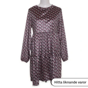 Mönstrad kortklänning i satin - Snygg kortklänning med lång ärm och rund hals, tillverkad i glansigt satinmaterial. Rynkade detaljer nertill, går till strax innan knäna på mig som är 165