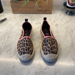 Leopardmönstrade espadrillos från ONLY - Helt oanvända nya espadrillos från ONLY med leopardmönster och rosa kantband. Skorna har en platt sula i flätad jute och ovandel i textil. 