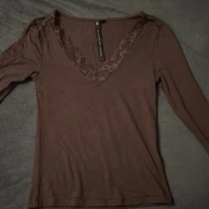 Brun långärmad topp med spets - Säljer en brun spets topp från lager157 storlek S aldrig använt. Kan diskutera pris