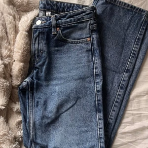 Weekday Arrow Low Straight Jeans blå - Säljer ett par Weekday Arrow Low Straight Jeans i klassisk blå tvätt. Modellen har låg midja, raka ben och fem fickor med snygga kopparfärgade nitar. Jeansen är tillverkade i slitstarkt bomullsjeansmaterial och har en läderpatch med Weekday-logga bak.