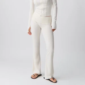 Vita bootcut byxor med vikkant - Snygga ljusbeige bootcut byxor med vikkant i midjan. Byxorna har en mjuk och stretchig känsla, perfekt för en avslappnad och trendig look. Passformen är normal och materialet ser ut att vara bomull eller syntetblandning. Helt nya med prislapp☺️