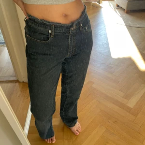 Mörkblå jeansbyxor från Vila XS - Säljer ett par mörkblå jeansbyxor från Vila i storlek XS. Byxorna har rå kant upptill i midjan, klassiska fem fickor och raka ben. Jeansen har kontrastsömmar och är tillverkade i ett mjukt denimtyg som känns skönt att bära.