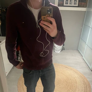 Zip up - Vinröd kofta från Tommy Hilfiger i pima bomull och kashmir. Klassisk modell med dragkedja hela vägen, ribbade muddar och liten logga på bröstet. Tröjan är i använt skick, hör av dig vid minsta lilla fundering!