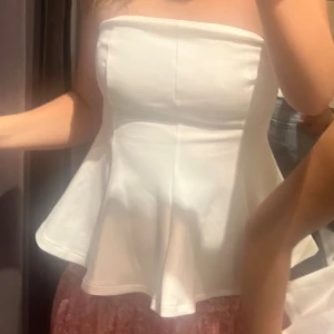 Vit axelbandslös peplum tubtopp - Säljer en vit axelbandslös tubtopp från Zara i strl s
