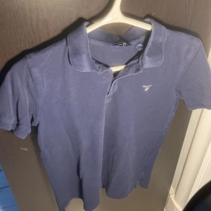 Mörkblå Gant pike - Stilren piké ifrån Gant. Klassisk look och perfekt för lite festligare outfit. Ny pris 1000kr. Säljes för 300. Passar runt 170-180