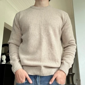 Stickad tröja från Benetton - Säljer en schysst beige stickad tröja från Benetton | Storlek Medium | Modellen på bilden är 178cm | Hör av dig vid minsta fundering
