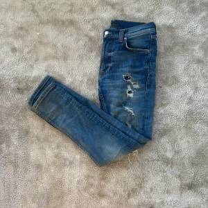 Nudie jeans  - Säljer ett par riktigt feta nudie jeans. Rikigt snygga jeans med ett par läckra slitningar. Väldigt fint skick, inga defekter eller liknande, storlek 25 W 28 L, skulle säga att jeansen passar runt 170 och neråt. Slim fit, skick 8/10 