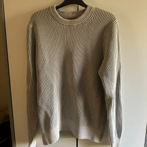 Beige ribbad stickad tröja Vailent - Säljer en beige stickad tröja från Vailent i storlek XS. Tröjan har ett ribbat mönster och rund halsringning. Långärmad och perfekt för dig som gillar enkel och clean stil. Passar dig som vill ha en snygg och bekväm tröja till hösten eller vintern.