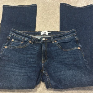 Mörkblå jeans från 157, storlek M - Snygga mörkblå jeans från 157 i klassisk femficksmodell. Jeansen har kontrastsömmar, raka ben men lite utsvängda längst ner och normal passform. Tillverkade i bomull med en skön jeanskänsla. Perfekta för dig som gillar enkel och stilren denim.