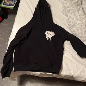 Svart hoodie från 4Thelove XS - Svart hoodie från 4Thelove i storlek XS med vit broderad text och hjärtdetalj på bröstet. På huvan står det 'LOVE' i vitt med ett coolt droppande hjärta. Klassisk känguruficka och utan  snörning i huvan. Perfekt för dig som gillar streetstyle. 4Thelove är ett eget uppfunnit märke i Linköping som är väldigt bra kvalité och är len inuti i materialet. Storleken är större i denna tröja så passar för både XS&S. Köpt för 750 kronor men säljer för 300 för att den börjar bli för liten.Pris kan diskutera