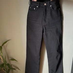  Weekday Rowe jeans W28 L32 - Säljer ett par svarta jeans från Weekday, modell Rowe i storlek W28 L32. Byxorna har raka ben, klassisk femficksdesign och hög midja. Materialet är kraftig denim i bomull. Snygga och stilrena jeans som passar till det mesta. 