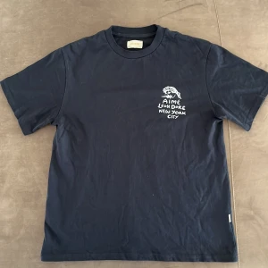 Mörkblå Aimé Leon Dore t-shirt S - Mörkblå t-shirt från Aimé Leon Dore med vit tryckt grafik och text både fram och bak. Snygga prints. Hör av er vid eventuella frågor eller annat. Pris går att diskutera!