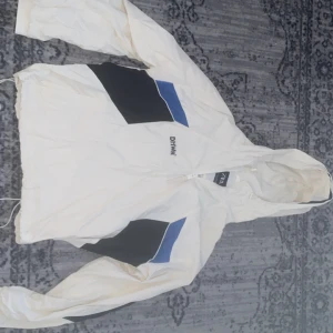 Zara vindjacka - Snabb leverans! 🚚 dm för fler bilder! Snygg vit vindjacka från Zara med svarta och blå detaljer. Jackan har huva, dragkedja framtill och meshfoder på insidan. Perfekt för dig som gillar sportig stil och vill sticka ut med coola färgblock. Justerbar nederkant med snörning och långärmad modell.