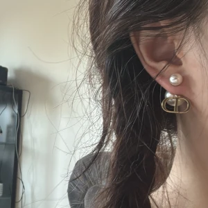 Dior örhängen med pärlor  - Säljer ett par Dior Tribales örhängen med vita pärlor och guldfärgade detaljer. Ny pris 4500kr. Äktenhetsbevis finns🩷