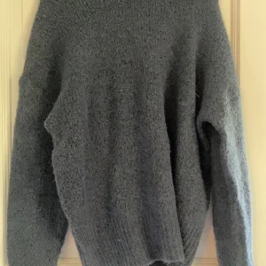 Blå stickad tröja från 157 - Mysig Blå stickad tröja från 157 i storlek S. Tröjan har en enkel och avslappnad passform med långa ärmar och grovstickad struktur som ger en cool och chill vibe. Perfekt för lager på lager under kyliga dagar. PRIS KAN DISKUTERAS