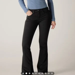 Svarta  jeans Replay - Snygga svarta jeans från Replay. Jeansen har en låg midja och är tillverkade i stretchigt jeansmaterial för skön komfort. Diskret broderad detalj på bakfickan och knappstängning framtill.    Nypris 1500