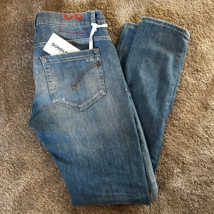 Dondup  - Tja! Säljer ett par Dondup jeans – modell George. Storlek W32, blåa med snygga slitningar. Sitter riktigt bra och är i helt nytt skick med tag kvar. Nypris: 3200kr , mitt pris: 900kr