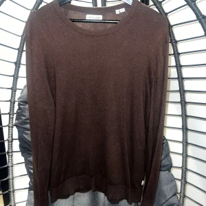 Brun långärmad tröja  - Mörkbrun, tunn och stilren långärmad tröja från Jack & Jones. Tröjan har rund halsringning och är tillverkad i ett mjukt material som passar perfekt för lager-på-lager. Enkel design som funkar till många outfits.