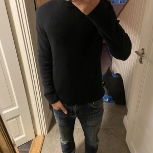 Mörkblå stickad tröja från H&M XS - En svart stickad tröja från H&M i storlek XS. Passar bra till hösten då den är tjock och värmer bra. Väldigt fint skick och inga defekter. Passar från 170-180 eftersom den är lite stretch och kan anpassas till längd. Hör av dig om jag ska skicka fler bilder. Mörkblå