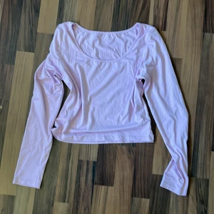 Ljuslila långärmad topp - En enkel och stilren ljuslila långärmad topp med rundad halsringning. Toppen är croppad och har en mjuk, skön känsla i bomullsmaterial. Perfekt att matcha med jeans eller kjol för en chill look.